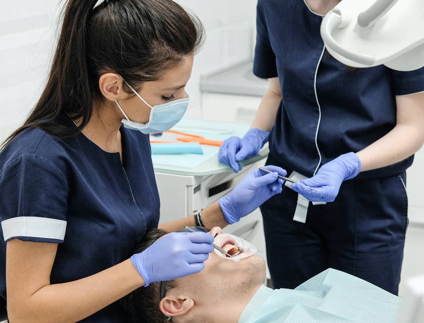 dentist and dental assistant cleaning teeth
