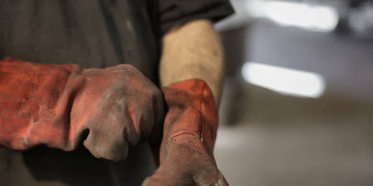 A laborer wearing heavy-duty gloves.