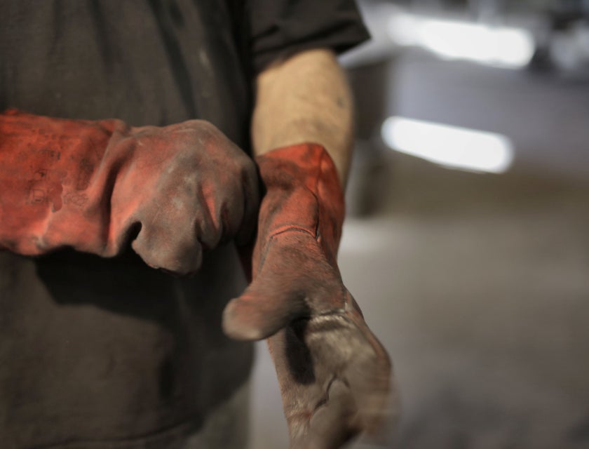 A laborer wearing heavy-duty gloves.