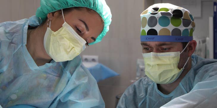 An OR nurse assisting a doctor.