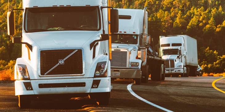 white semi trucks on a road