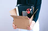 Empleado despedido sosteniendo una caja con sus pertenencias..