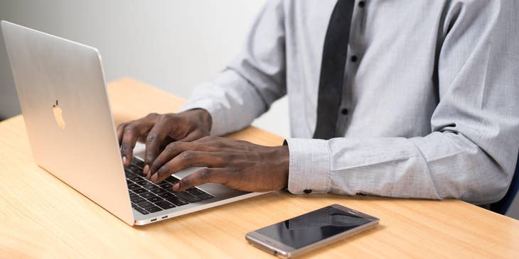 Man using a laptop to list his references on a resume