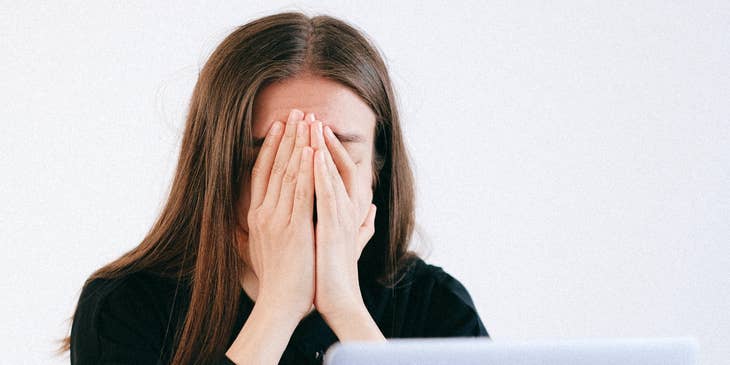 A woman sitting in front of a laptop after being laid off.
