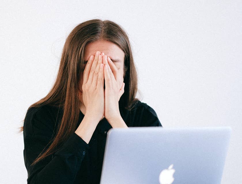 A woman sitting in front of a laptop after being laid off.