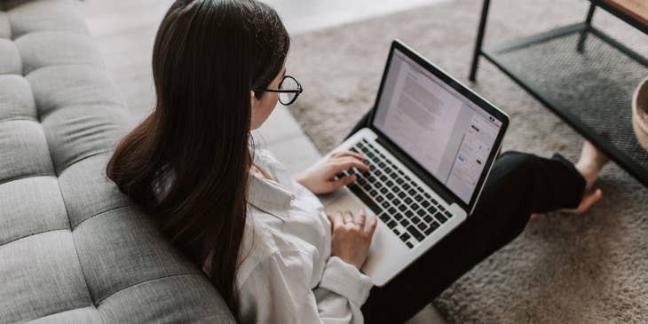 Woman writing a virtual assistant cover letter on a laptop