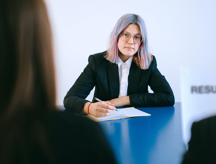 Person reading a woman's HR Assistant resume during a job interview