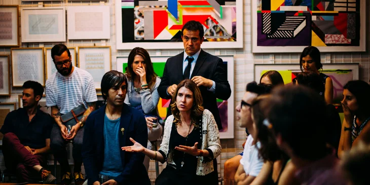 A Human Rights advocate in a suit attending a human rights meeting to observe and gather information on people's interests.