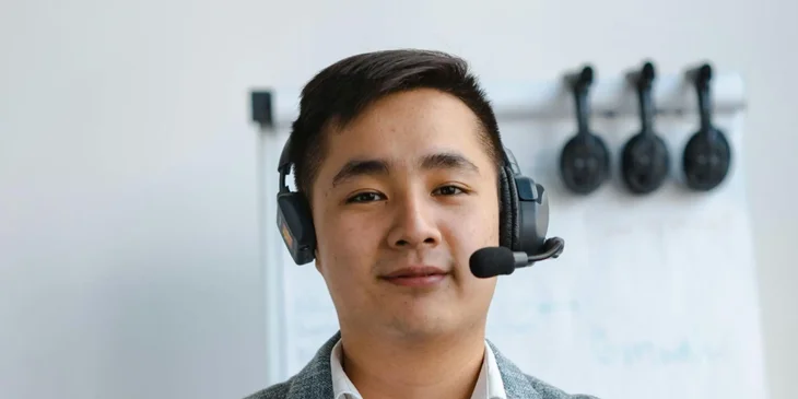 A maritime communications professional working and wearing a headset.