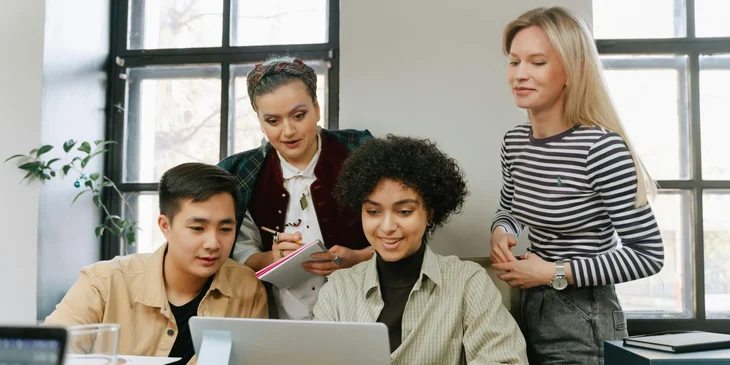 Coworkers looking at a presentation on a laptop.