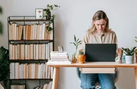Una mujer trabajando en su computadora portátil.