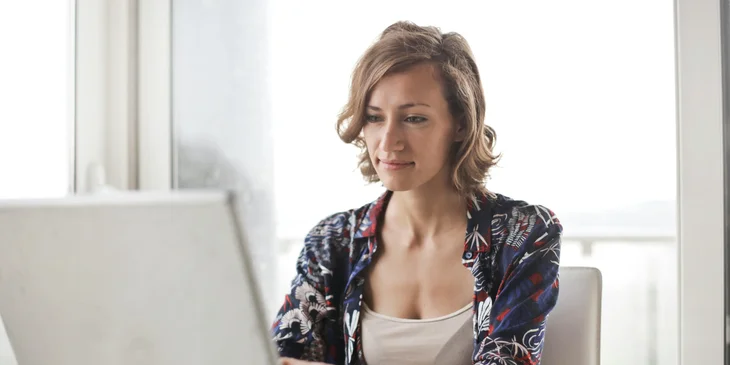 A woman working at her desk using a laptop.
