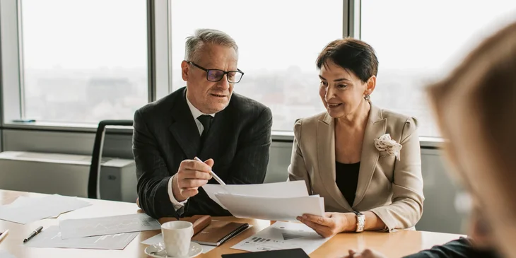 A man and a woman discussing business matters in the office together.