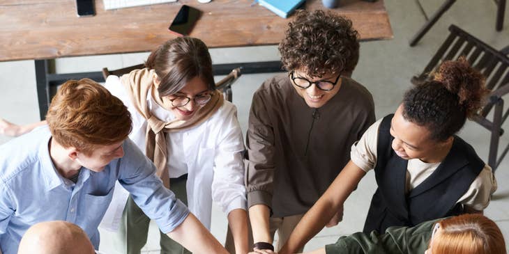 Employees guided by inclusive leadership principles are joining hands.