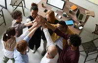 Funcionários guiados por princípios de liderança inclusiva unindo as mãos.