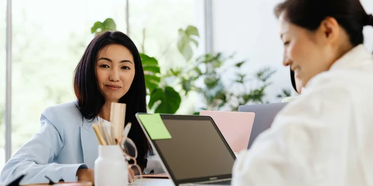 Two female colleagues happily working.