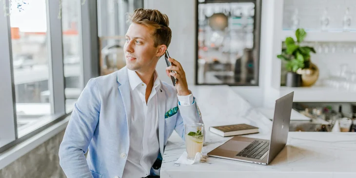 A man sitting and speaking to someone on a mobile phone.
