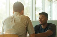 Un gerente platicando con un empleado sobre su insubordinación en el trabajo.