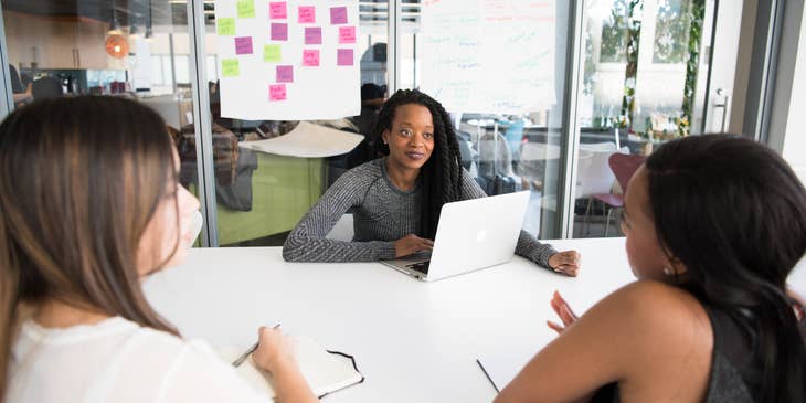 An interaction designer discussing a project with two co-workers.