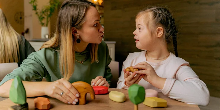 An intervention specialist narrates a story to a child using animal toys.