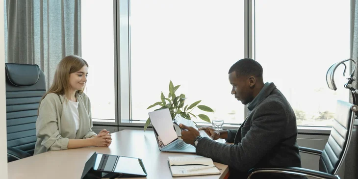 A Human Resources team member interviewing a woman for the role.