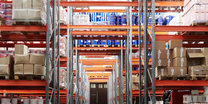 View of inventory in a warehouse aisle, with shelving and products.