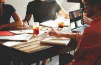 Pessoas sentadas ao redor de uma mesa concluindo a integração profissional.