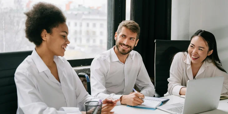 A group of cheerful coworkers in an office having a meeting.