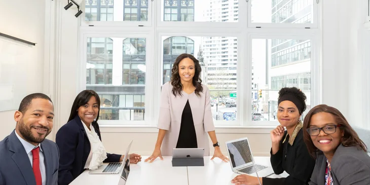 A group of professionals in a boardroom overlooking the city.