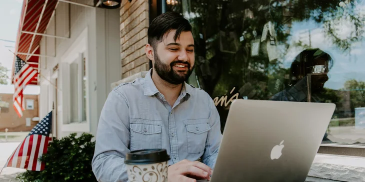 A man working on his laptop outdoors.