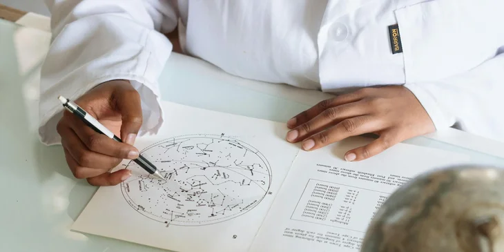 An astronomer studying an astronomical map in a research center.