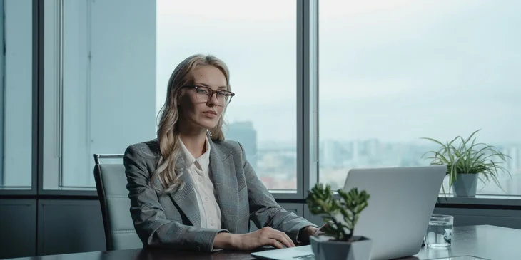 A woman sitting while working on her laptop.