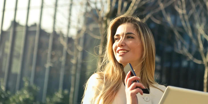 A smiling woman outdoors in the early morning.