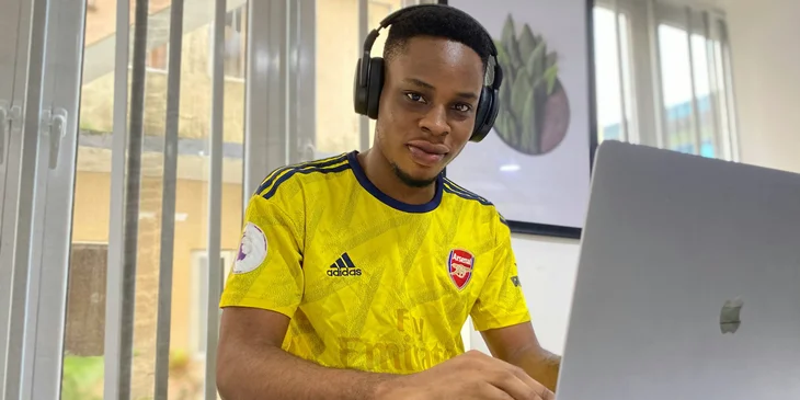 A man in yellow and blue shirt wearing a black headphones.