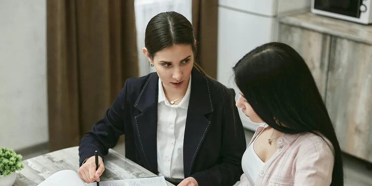 An HR representative discussing the contract with the newly hired woman.