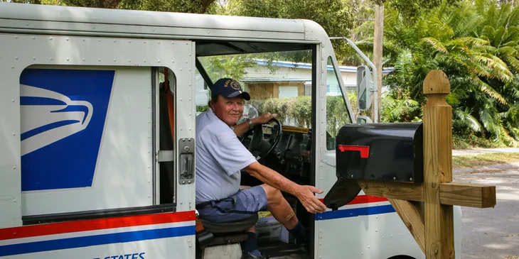 A truck driver stepping in a truck.