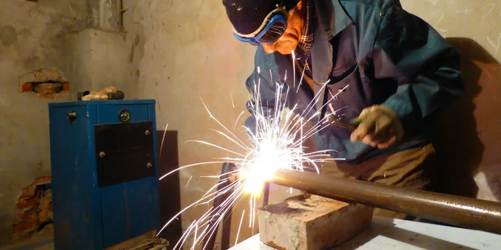 A man welding a steel rod.