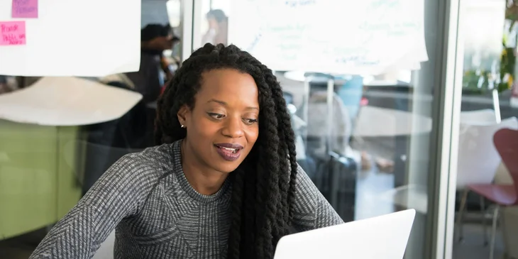 A woman participating in a video conference on her laptop.