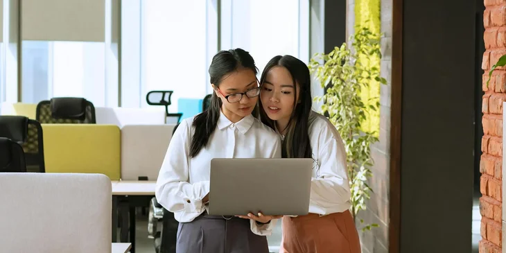 Two women looking at a laptop.