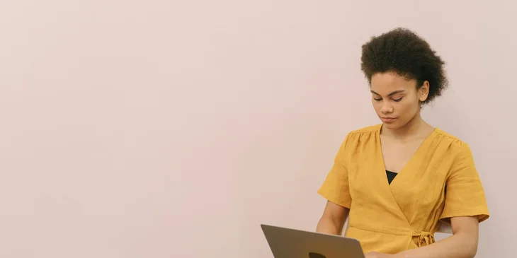 A woman seated and working on her laptop.