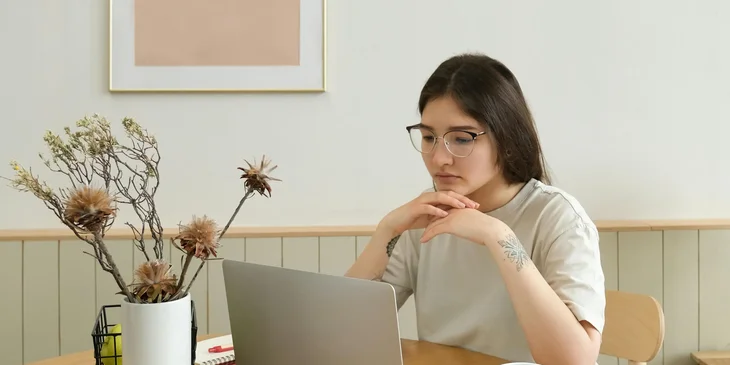 A woman reviewing a document on her laptop.