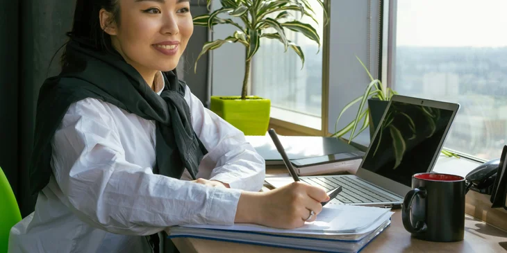 A woman sitting in an office with a view.