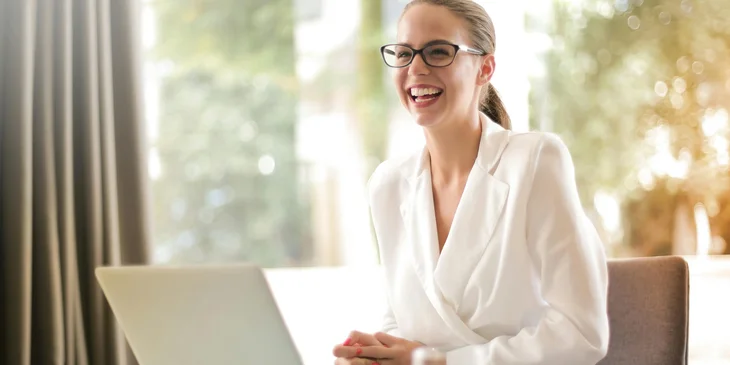 A laughing lawyer working in an office with a laptop.