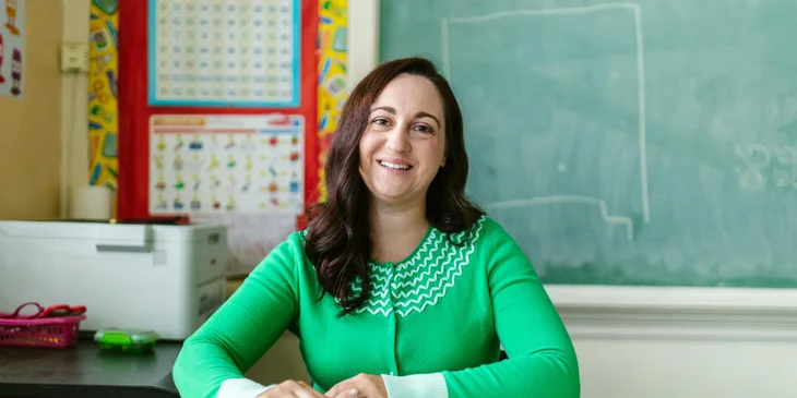 A teacher sitting in a classroom.