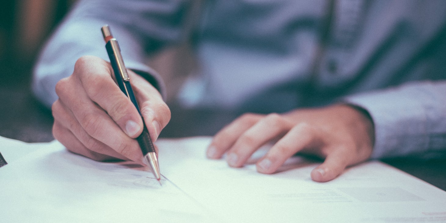 A person writing a letter of recommendation.