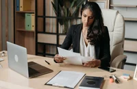 Una manager che legge una lettera di licenziamento prima di consegnarla.