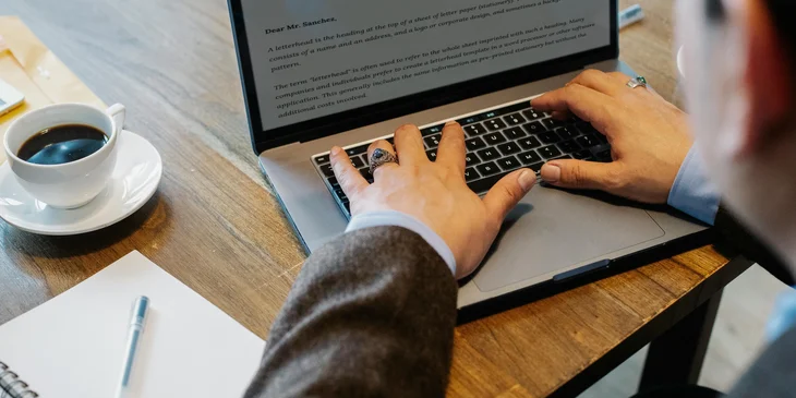 A litigation paralegal drafting a legal letter on his computer, following instructions from an attorney.