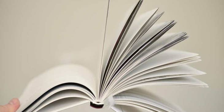 Un manual del empleado abierto contra un fondo blanco.