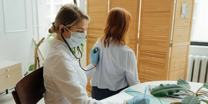A doctor examining a patient with a stethoscope.