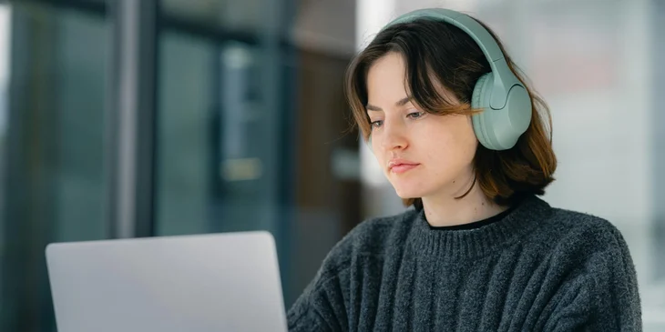 A medical records technician listens to an audio recording and converts it into electronic healthcare records.
